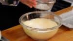 Add half of the cake flour while sifting.