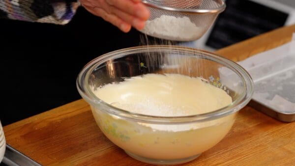 Add half of the cake flour while sifting.