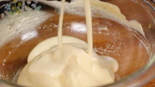 Then, add the milk to the batter in the bowl.