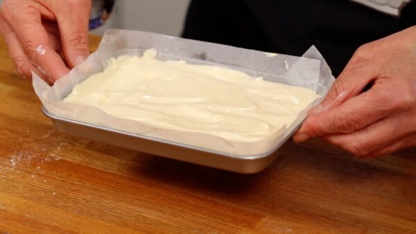 Drop the tray twice from a height of about 5 cm (2") to remove large air bubbles in the batter.