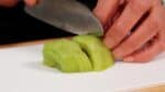 Let's prepare the rose-shaped fruit topping. Slice the kiwi very thinly. You can also make beautiful orange roses with mango, or use a popular combination of whole strawberries and blueberries.