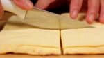Veeg het lemmet van het mes af met een natte doek. Snijd de taart door de lengte in de helft en snijd dan de andere helft kruiselings om kwarten te maken. 