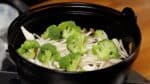 Then, add the shimeji mushrooms, enoki mushrooms, and broccoli.