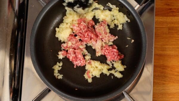 Then, add the ground pork and stir-fry thoroughly while breaking it up.