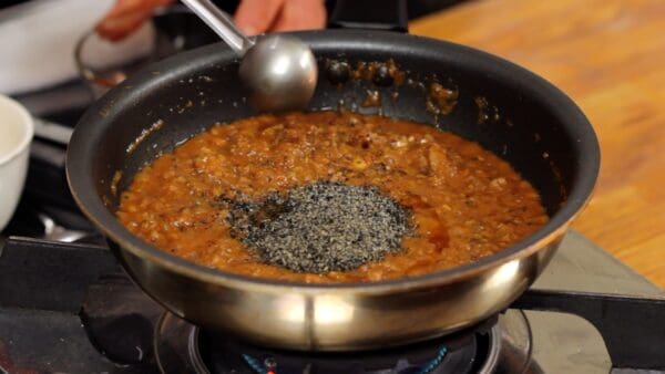 Quand l'eau s'est un peu évaporée et que le mélange a épaissi à ce point, ajoutez les graines de sésame noires moulues et l'huile de sésame.