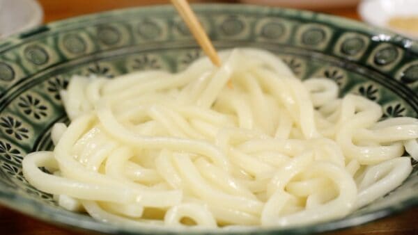 Then, place the udon onto a plate and spread them out. Alternatively, you can try making it with cold udon noodles. When the boiled udon noodles are cooled down in ice water, they become firm and chewy and have a delicious texture.