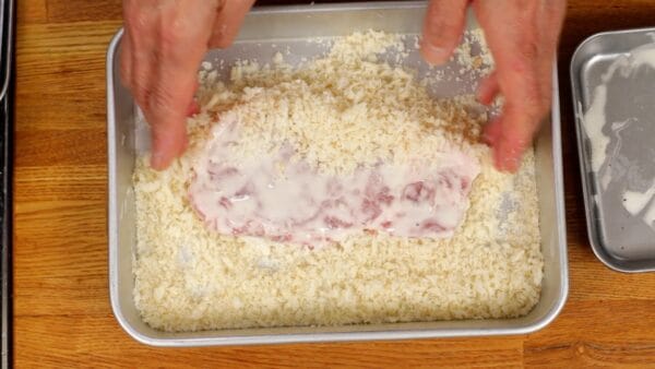 豚ロース肉にパン粉をかぶせて上から押して剥がれにくくします。