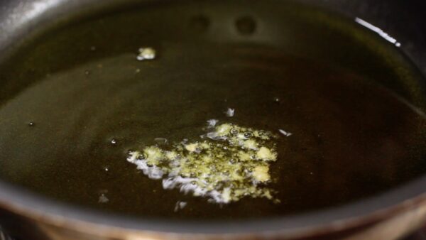 Now, let's make the tonkatsu. To check the oil temperature, drop a bit of breadcrumbs into the pan.