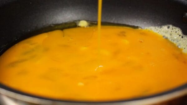 If it floats up with a sizzling sound, pour the entire egg mixture into the pan at once.