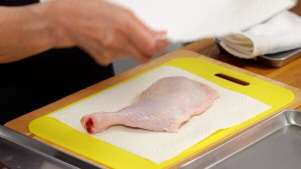 First, remove any excess moisture from the surface of the chicken thigh using a paper towel.