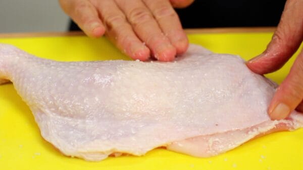 Flip the chicken over, and rub the remaining one-third of the salt into the skin.