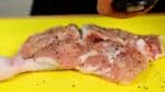 Placez le poulet avec le côté viande vers le haut et saupoudrez-le généreusement de poivre noir grossièrement moulu.