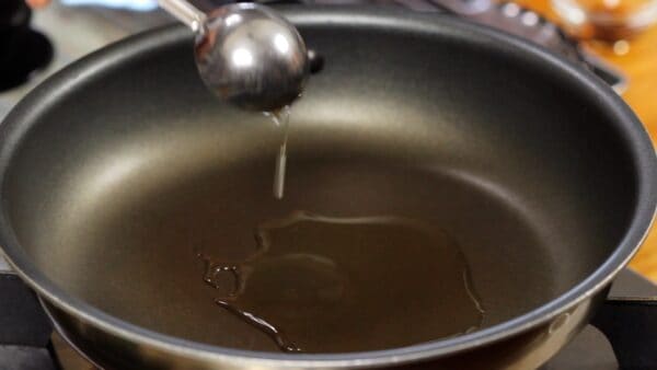 Now, let's cook Honetsuki-Dori! Heat the olive oil in a frying pan.