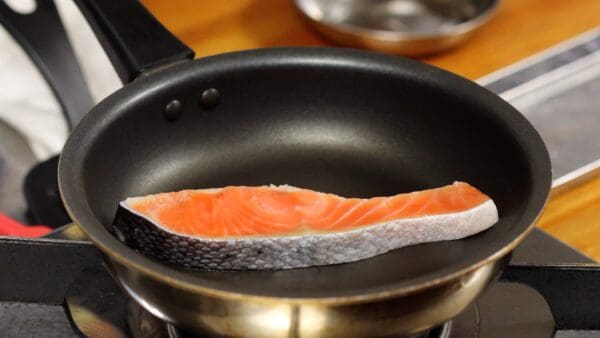 First, let's pan-fry the lightly salted salmon. Heat a frying pan and lightly sear both sides of the salmon.