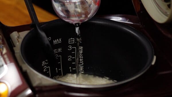 Add water, but use slightly less than the specified measurement for the rice. Using less water helps prevent the rice from becoming too soft since the mushrooms contain water.