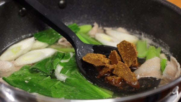 Now, add the chopped curry sauce mix. Take some of the broth with a ladle and dissolve the curry sauce mix in it.