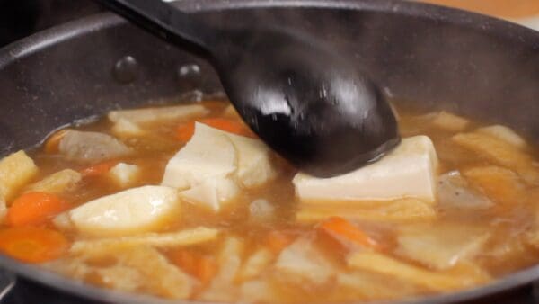 Gently place the tofu in the pot to prevent splashing and break the tofu into smaller pieces with a ladle.