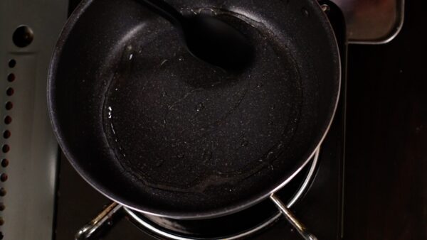 Spread the vegetable oil evenly across the pan with the back of a ladle.