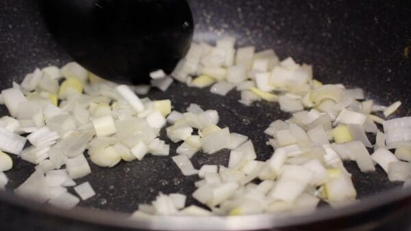 Next, add the vegetable oil to the pan again. Stir-fry the chopped long onion until it changes color slightly.