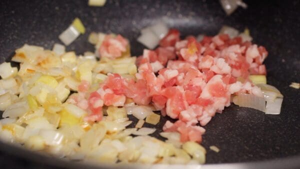 Once the garlic starts to give off a fragrant aroma, add the chopped pork belly.