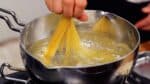 Gently press the pasta into the pot, being careful not to break it. Today, we're using thin pasta called capellini.