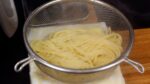 Place the noodles in a mesh strainer, then hit the strainer against a kitchen towel numerous times to remove excess water.