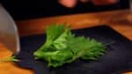 Let's prepare the shiso leaves. Remove the stems from the shiso leaves, and cut them in half crosswise.