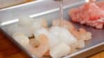 Transférez le mélange de fruits de mer dans un plateau. Ajoutez le saké au mélange de fruits de mer et mélangez pour bien enrober. Oui, nous cuisinons avec du saké, nous ne le buvons pas... pour l'instant.