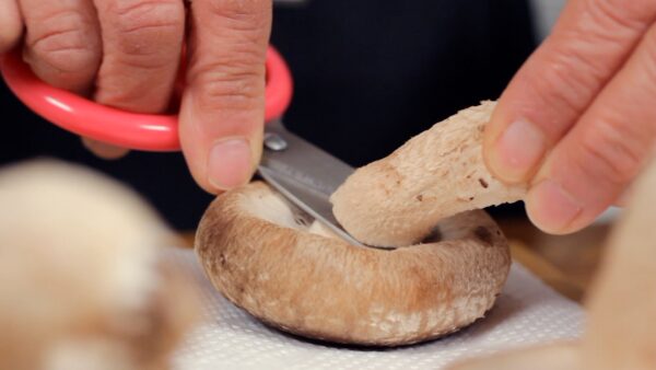 椎茸の下準備をします。椎茸の軸はハサミで切り取ります。包丁のかわりにハサミを使う方が簡単で安全です。