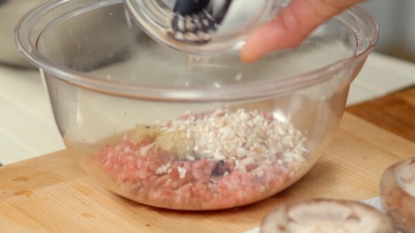 ボウルに豚ひき肉、しょうゆ、オイスターソース、酒、砂糖、おろし生姜、ごま油、こしょう、刻んだ椎茸の軸を入れます。