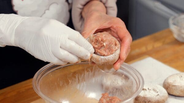 肉だねを1個取り、椎茸にのせて軽く押さえます。指先をほんの少し水で濡らすと表面がきれいに仕上がりますよ。